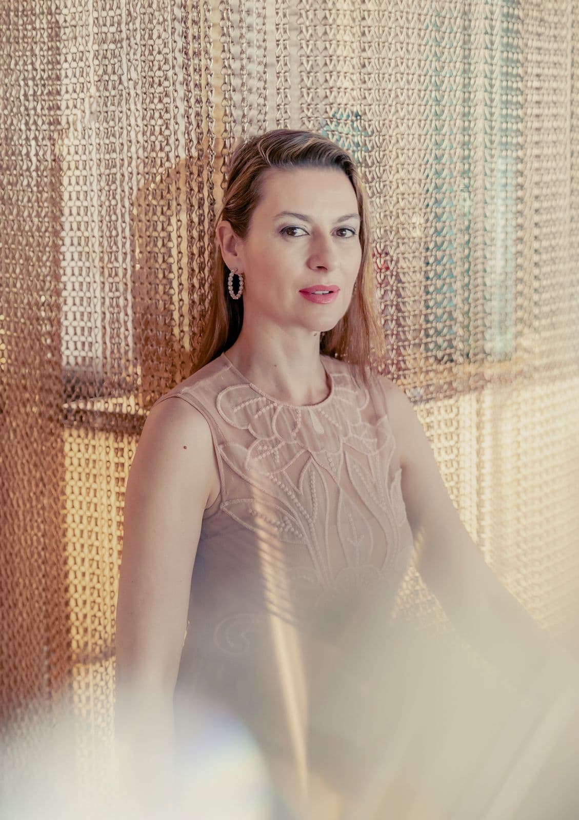 Chen Reiss behind a golden chain curtain